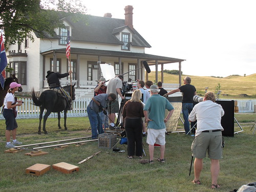 A film crew surrounds the talent on the grounds at Fort Abraham Lincoln.