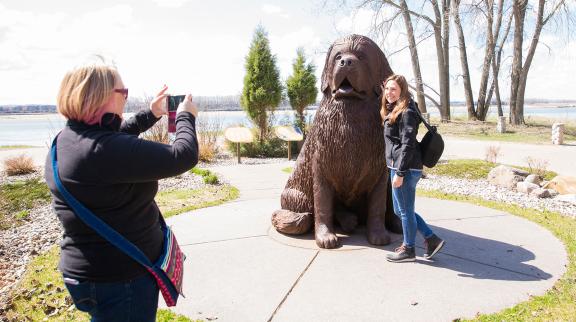 Women taking pictures with the dog statue at Fort Mandan