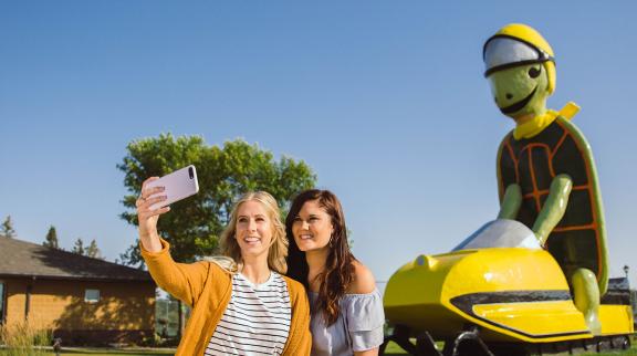 Women take a selfie in front of Tommy the Turtle