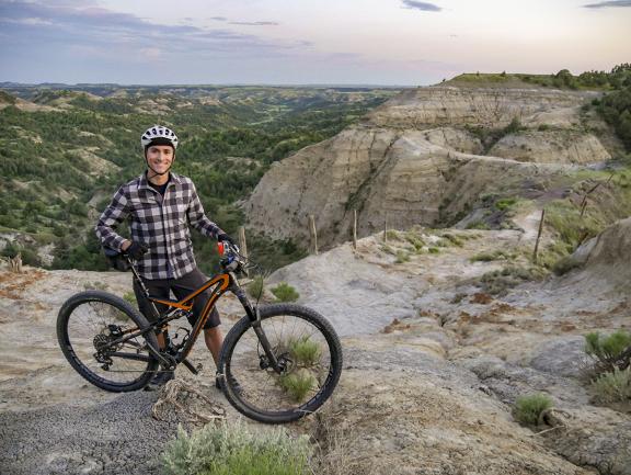 man on bike on a cliff