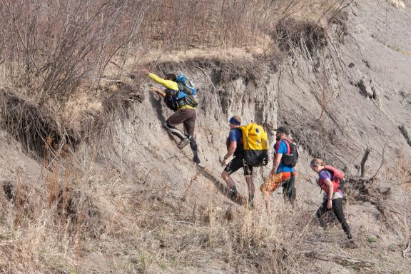 Hikers climbing up a dirt hill