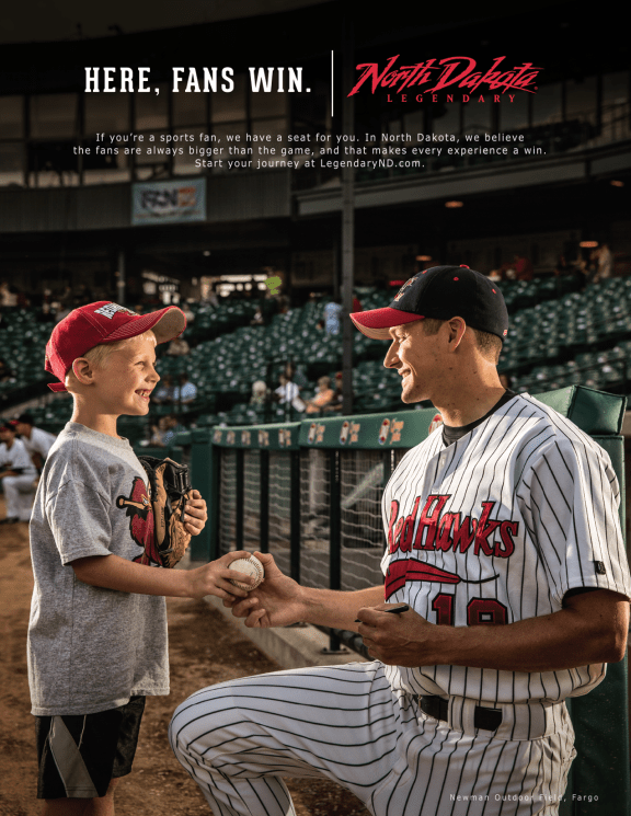 A member of the Red Hawks team hands a ball to a child
