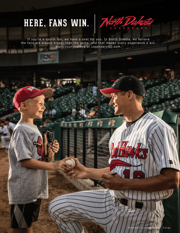 A member of the Red Hawks team hands a ball to a child