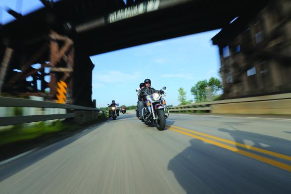 Motorcycle rider passing under a bridge
