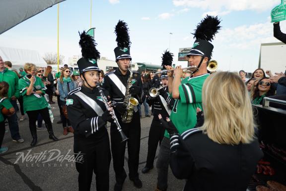 People dressed in uniforms and green attire interacting