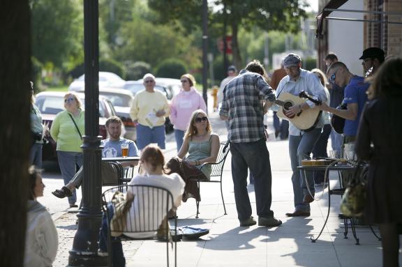 A group of people gathered outside, enjoying a street performance