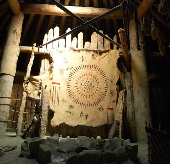 Lodge features a large, circular hide decorated with indigenous artwork and symbols, hanging prominently in the center