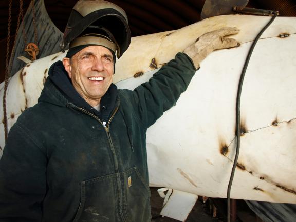 Gary Greff smiling beside a horse statue