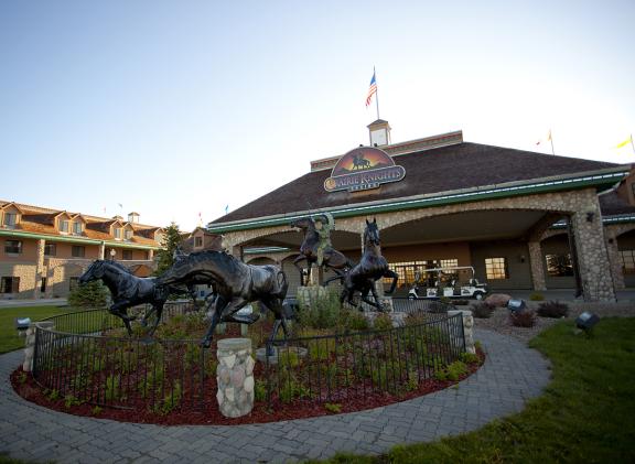 The entrance of the casino features a landscaped garden with life-size horse statues