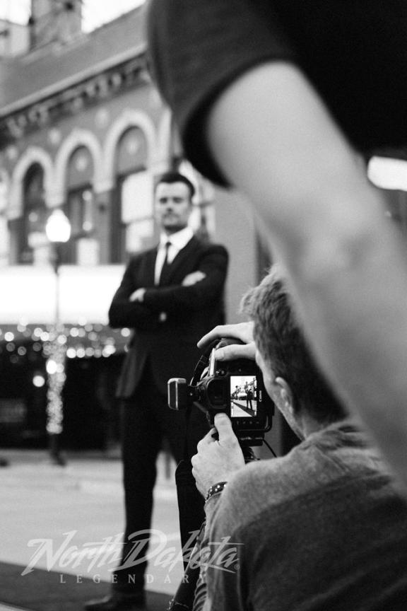 A man in a suit being photographed outdoors