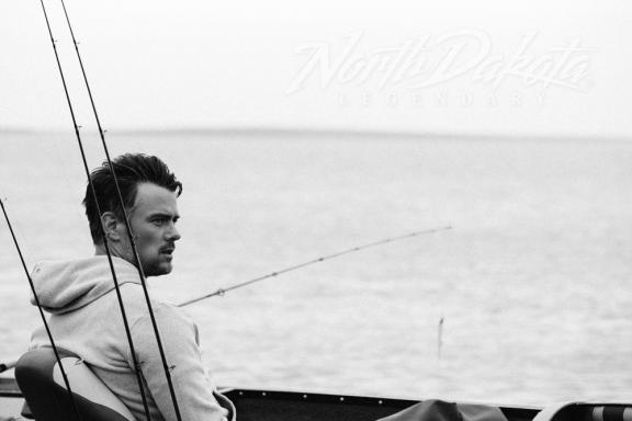 A man fishing, sitting in a boat