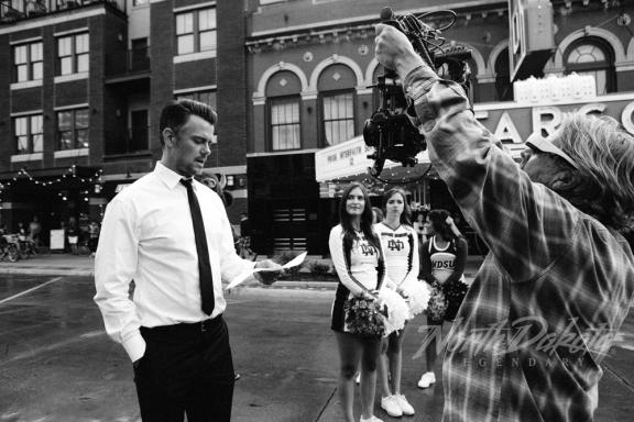 A man in a suit interacting with someone in a costume 