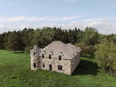 historic stone mansion set in lush green countryside surrounded by evergreen trees, offering heritage exploration and scenic natural landscape experiences. photo