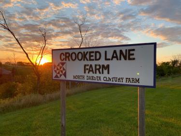 sunset over wild rice river showing crooked lane farm sign photo