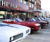 classic american muscle cars lined up on a city street near a storefront, showcasing vintage automotive heritage and nostalgia. photo 2